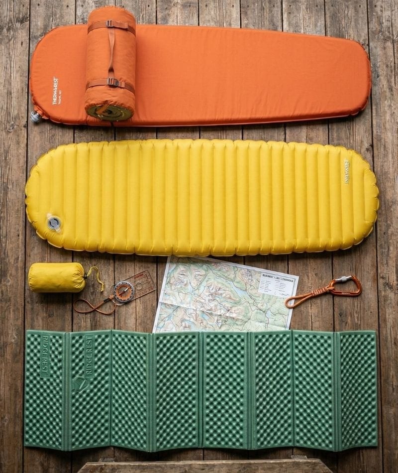 Tre typer liggeunderlag side om side — selvoppusteligt, oppusteligt og EVA skumunderlag til camping og trekking