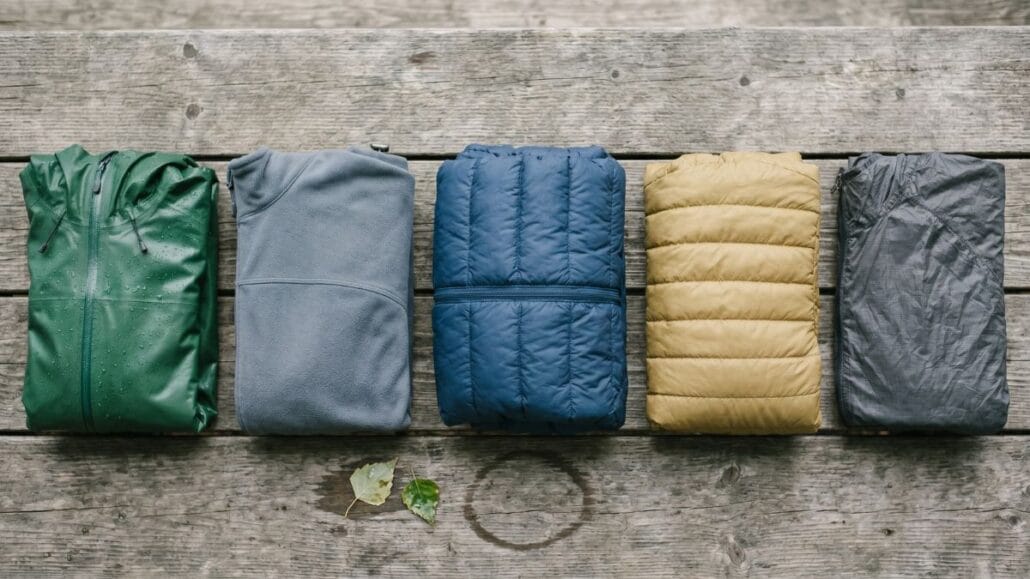 Fem outdoor-jakketyper foldet side om side: hardshell, softshell, dun, syntetisk og vindjakke